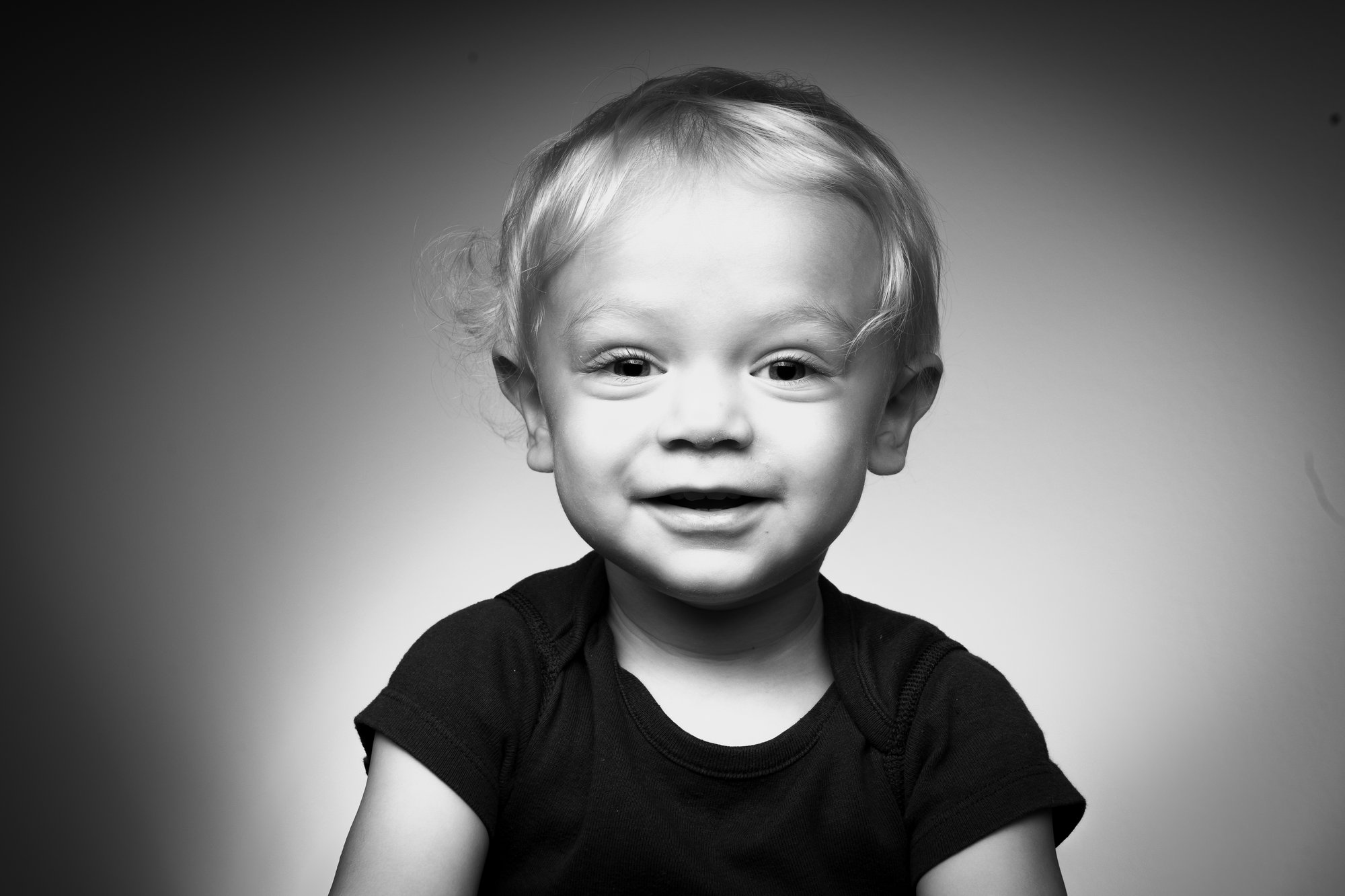 Black and white studio portrait of a smiling toddler